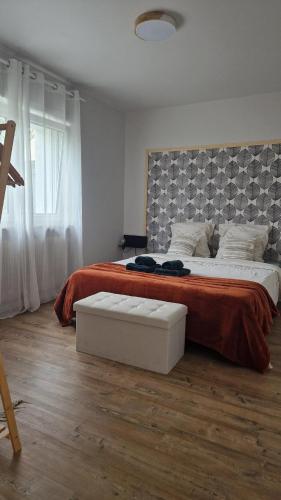 a bedroom with a large bed with a red blanket at La Maison des Petits Bonheurs in Rixheim