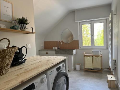 a washing machine in a kitchen with a window at La Maison des Petits Bonheurs in Rixheim