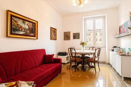 a living room with a red couch and a table at Vatica B&B Roma in Rome