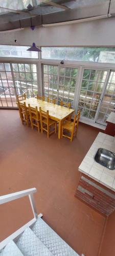 a table and chairs in a room with windows at Hermosa casa, parrilla, aire libre, 8 personas in Buenos Aires
