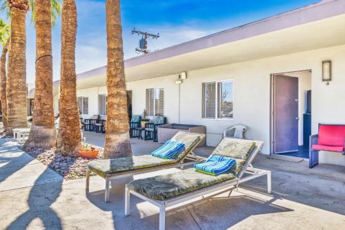 a patio with two chairs and palm trees at Lido Palms Resort and Spa in Desert Hot Springs