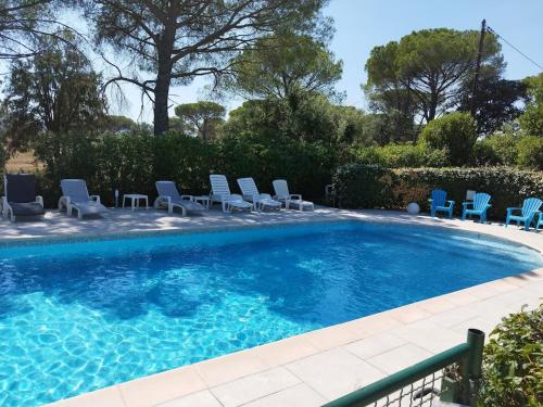 une piscine avec des chaises longues et une piscine dans l'établissement Villa à louer 12 personnes - Le Muy, au Muy