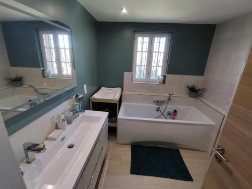 La salle de bains est pourvue d'une grande baignoire, d'un lavabo et d'une baignoire. dans l'établissement Villa à louer 12 personnes - Le Muy, au Muy