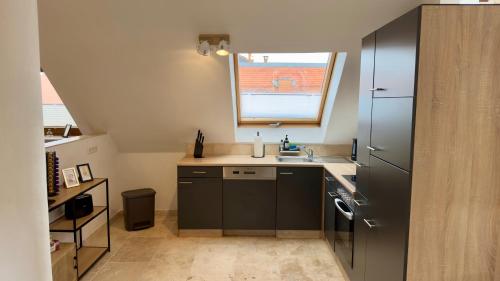 a small kitchen with a sink and a window at Design Penthouse im alten Schloss Deidesheim in Deidesheim