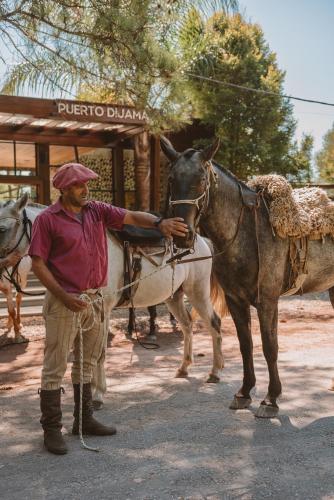 a man is standing next to a horse at Puerto Dijama Hotel Boutique in Carmelo