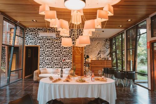 a dining room with a table and a chandelier at Puerto Dijama Hotel Boutique in Carmelo