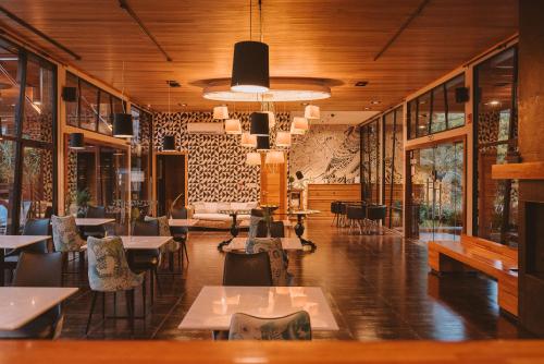 a restaurant with tables and chairs in a room at Puerto Dijama Hotel Boutique in Carmelo