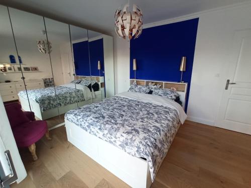 une chambre avec un grand lit et un miroir dans l'établissement La villa du bonheur, à Puilboreau