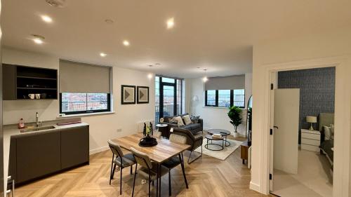 a kitchen and living room with a table and a couch at Serene- Stunning Two Bedroom 2 washroom, Spacious, dual aspect lounge, Jwellery Quarter, Birmingham City Centre in Birmingham