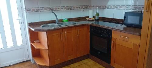 a kitchen with a sink and a dishwasher at Bonaire in Aldán