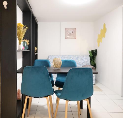 une salle à manger avec des chaises bleues et une table dans l'établissement Le Refuge à 8min Disneyland - Parking - 6 personnes, à Montry