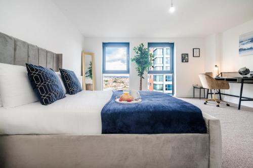 a bedroom with a large bed with a blue blanket at Penthouse Haven - Gants Hill - 2 Bedroom Flat in Redbridge