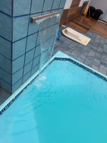 a swimming pool with a water fountain in it at Chácara Brunelli in Piracicaba