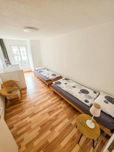 two beds in a room with a wooden floor at Paradise mit Seesicht in Fluelen