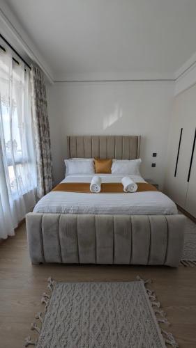 a large bed in a bedroom with a large couch at Forest View - Lavington in Nairobi
