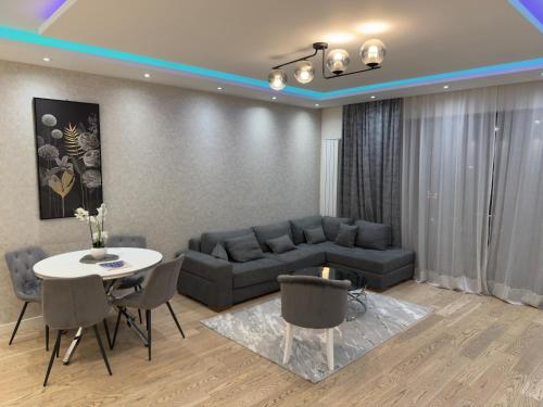 a living room with a couch and a table and chairs at Belgrade Waterfront Penthouse 17th last floor in Belgrade