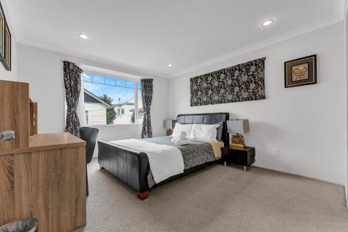 a bedroom with a bed and a window at Cozy Home in Epsom in Auckland
