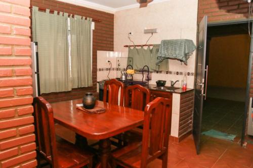 a kitchen with a wooden table with chairs and a sink at Departamentos Termas tu Segundo Hogar in Termas de Río Hondo