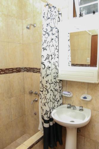 a bathroom with a sink and a shower curtain at Departamentos Termas tu Segundo Hogar in Termas de Río Hondo
