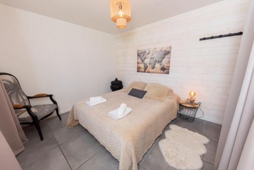 une chambre avec un lit avec deux serviettes dessus dans l'établissement Jolie Maison 84 m2 Océan Bordeaux Médoc Châteaux, à Salaunes