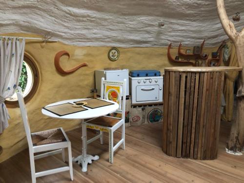 - un modèle de cuisine avec une table et un réfrigérateur dans l'établissement Maisonnette Kerterre en Bretagne, à Caudan