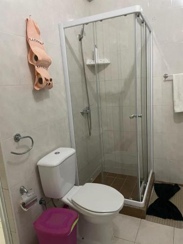 a bathroom with a toilet and a glass shower at Residencia BB in Praia