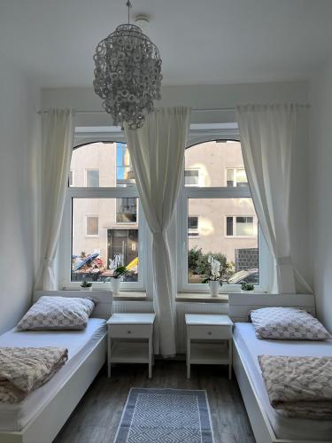 two beds in a room with two windows at City Appartement in Hannover