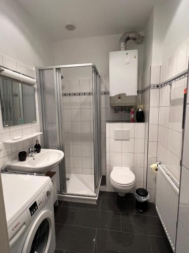 a bathroom with a toilet sink and a washing machine at City Appartement in Hannover