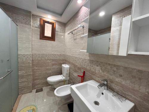 a bathroom with a white sink and a toilet at Sharm Hills Resort - 2Bedroom with Pool View and Beach Access in Sharm El Sheikh