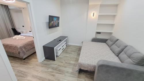 a living room with a couch and a bed at AIRPORT&APARTMENT&parking in Chişinău
