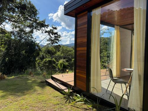 a house with a deck and a chair on a porch at Mont Baron Bike Hotel Fazenda in Teresópolis