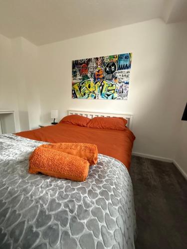 a bedroom with a bed with an orange comforter at Families and Contractors Dudley DY1 in Lower Gornal