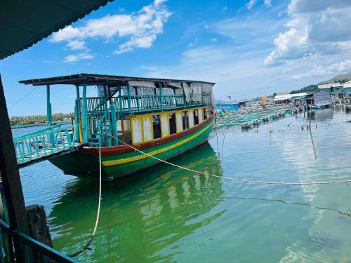 a boat tied to a dock in the water at MUY Hotel in Cửa Lò
