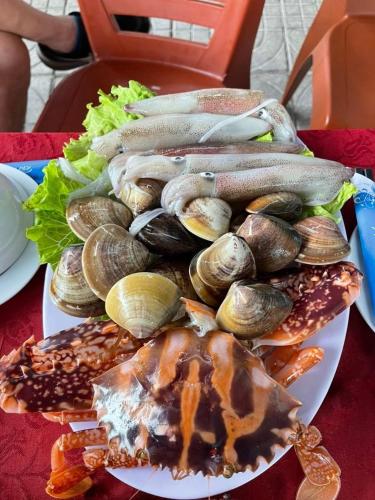 a plate of food with mussels on a table at MUY Hotel in Cửa Lò
