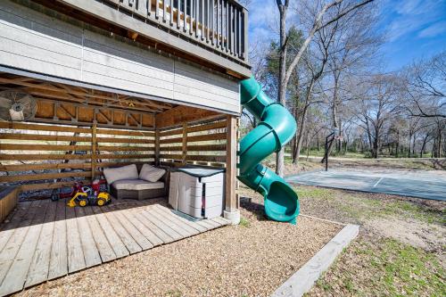 a playground with a slide next to a house at PickleballandSport Court Spacious Kemp Home! in Kemp