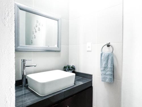 a white bathroom with a sink and a mirror at Casa Boutique Sabu in Oaxaca City