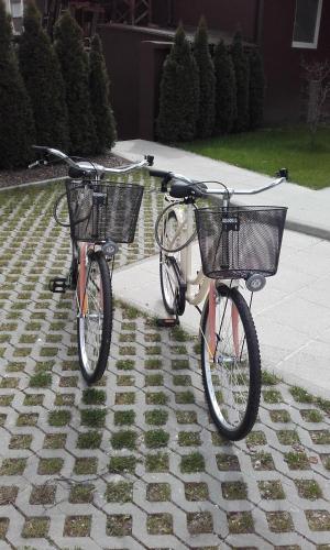 two bikes with baskets are parked on a sidewalk at WH Apartments in Ljubljana