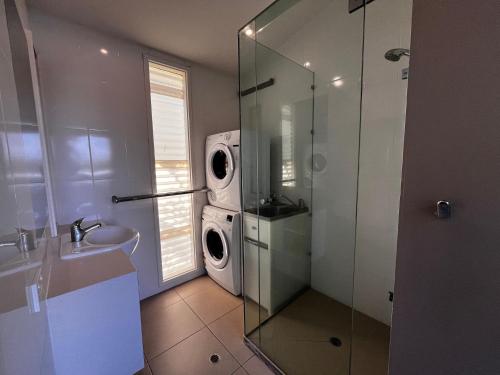 a bathroom with a washing machine and a sink at Rainbow North - Rainbow Beach in Rainbow Beach