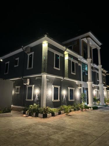 a large black house with white columns and lights at Grand T Abode Luxury Apartment in Ibadan