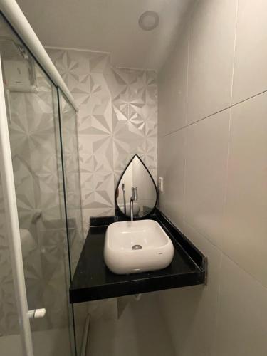 ein Badezimmer mit Waschbecken und Spiegel auf einer Ablage in der Unterkunft Studio Centro do Rio in Rio de Janeiro