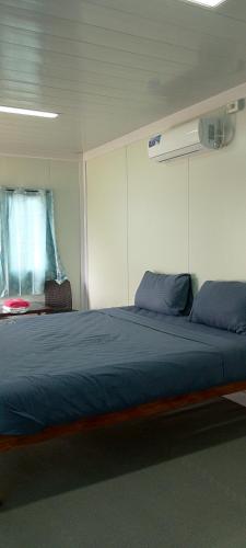 Un dormitorio con una gran cama azul en una habitación. en Anda Container House, en Anda