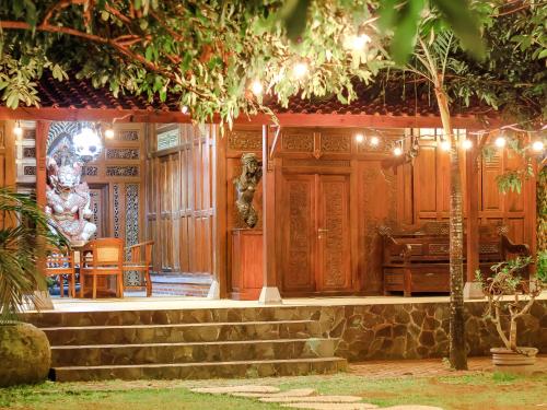 a porch of a house with a table and chairs at Pendhapa Art Space - PAS Limasan Homestay in Yogyakarta