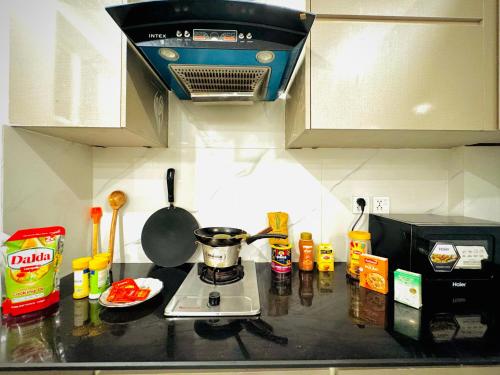 a kitchen counter with a pot on a stove at One Bed Designer Luxury Apartment Mehar Suites in Lahore