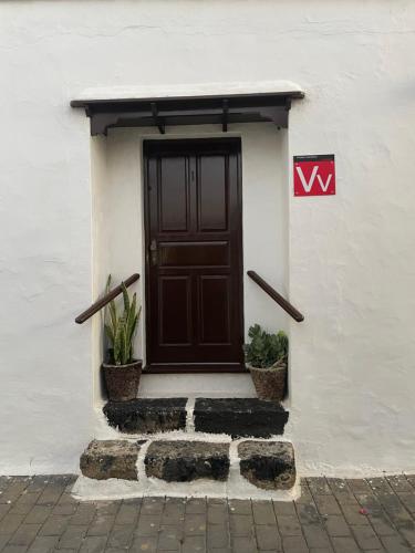 a door on the side of a white building with plants at Casa Tere in Teguise