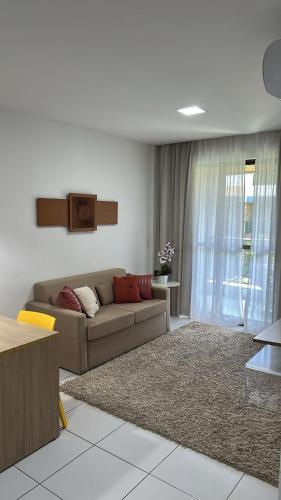 a living room with a couch and a rug at Apartamento no Iloa Residence - Com Enxoval Completo in Barra de São Miguel