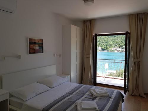 a bedroom with a bed and a view of the water at Apartments Vala 2 in Grebaštica