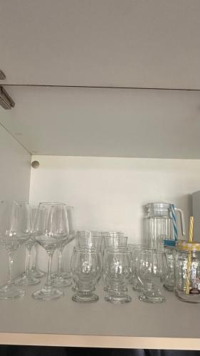 a row of wine glasses sitting on a shelf at Apartamento no Iloa Residence - Com Enxoval Completo in Barra de São Miguel