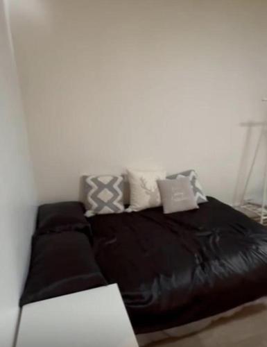 - un lit en cuir noir avec des oreillers dans l'établissement Cosy Studio in heart of Rue Mouffetard, à Paris