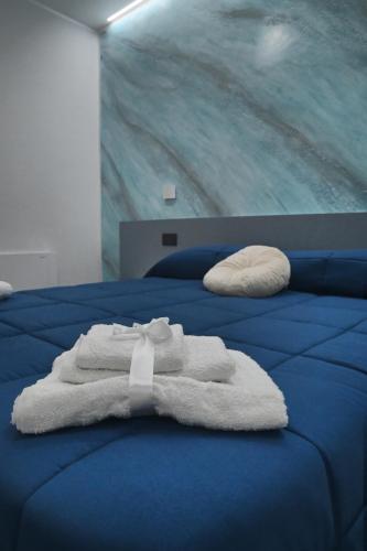 a white towel is sitting on a blue bed at Affittacamere ONE in Frascineto