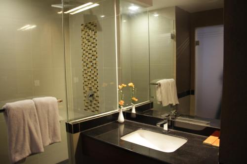 a bathroom with a sink and a large mirror at Cavinton Hotel Malioboro Yogyakarta by Tritama Hospitality in Yogyakarta